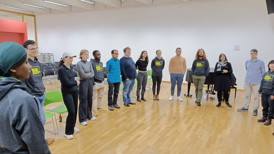 Gruppe von Menschen in einem Kreis in einem großen Raum