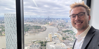Vincent Heimburg vor Fenster mit Blick auf die Themse Fluss in London
