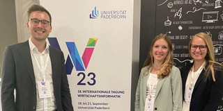 Vincent Heimburg, Amelie Schmid und Lisa Gussek vor einem Banner der WI 2023